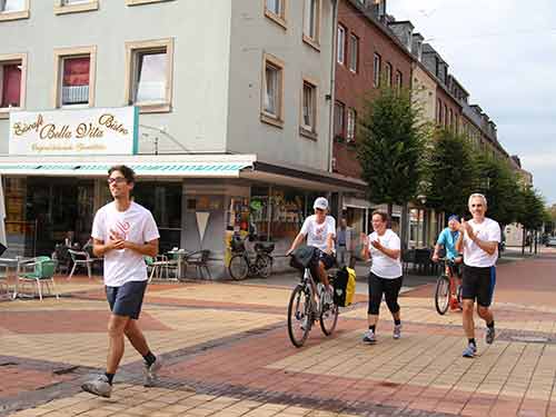 Mit dem Fahrrad und einem Kickboard begleiten zwei Friedensaktivisten den Lauf