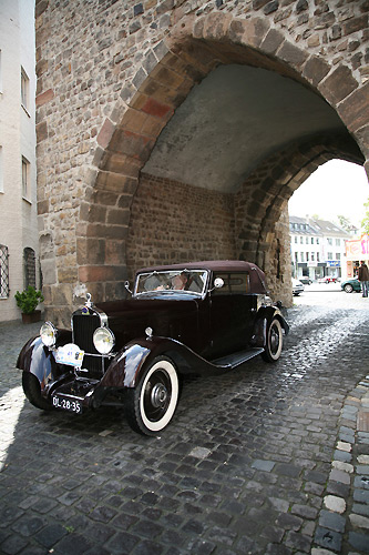 Und da sind sie: Ein motorisiertes Schätzchen durchfährt Jülichs Bau-Schätzchen, den Hexenturm. Foto: Dieter Benner